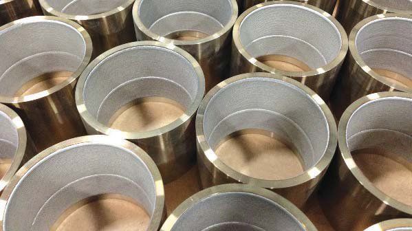 A bunch of metal cylinders are stacked on top of each other on a table.