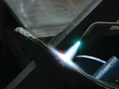A person is welding a piece of metal with a torch.