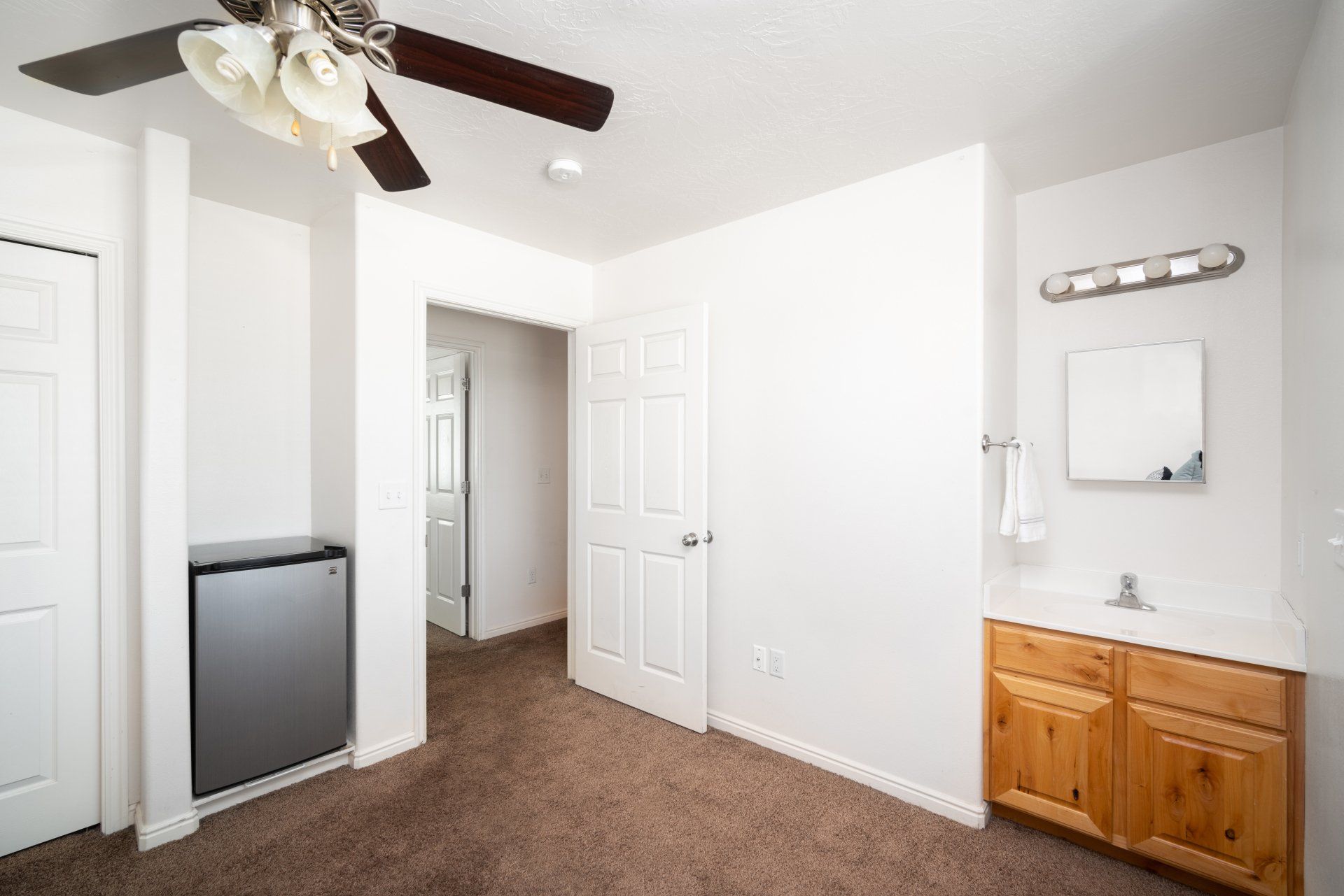 Spacious private bedroom with natural light, a study desk, and a comfortable bed in a student apartment