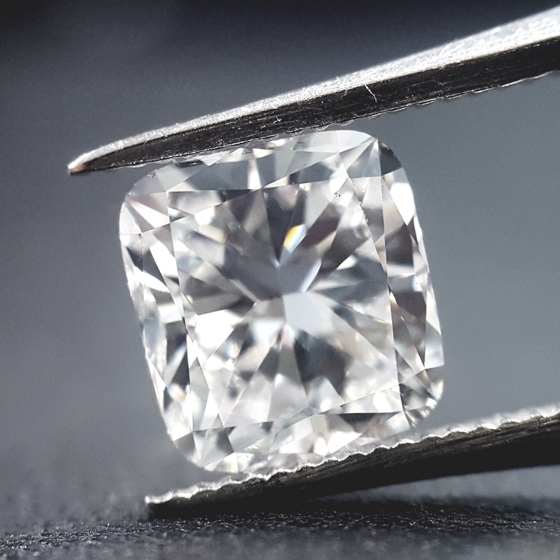 A close up of a diamond being held by tweezers