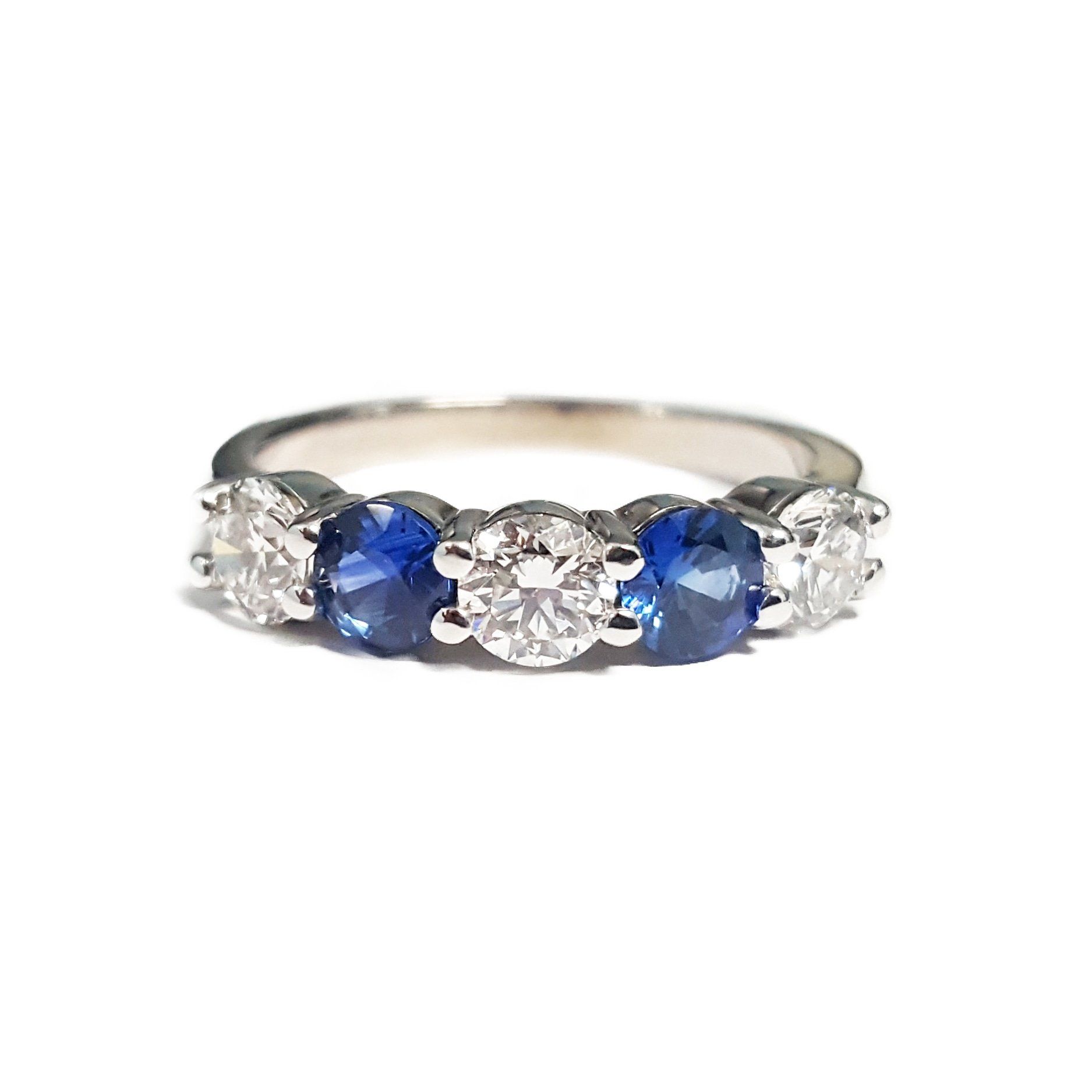 A white gold ring with sapphire and diamonds on a white background.
