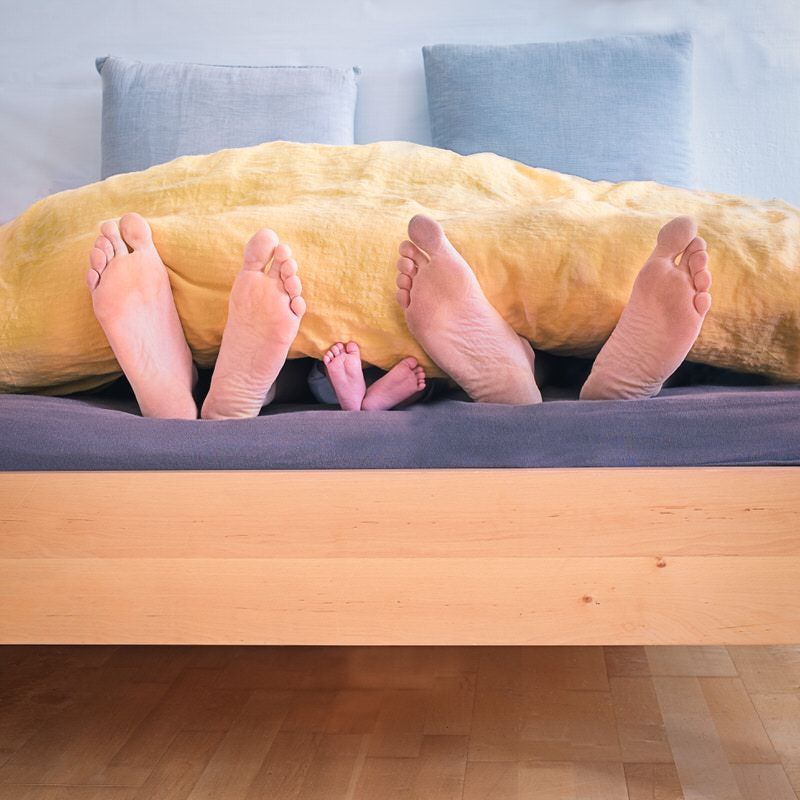 A family relaxes in bed knowing that their life insurance policy offers them tax-sheltered growth.