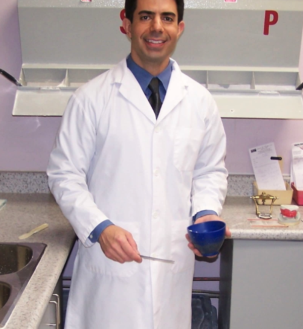 A man in a lab coat is holding a blue bowl
