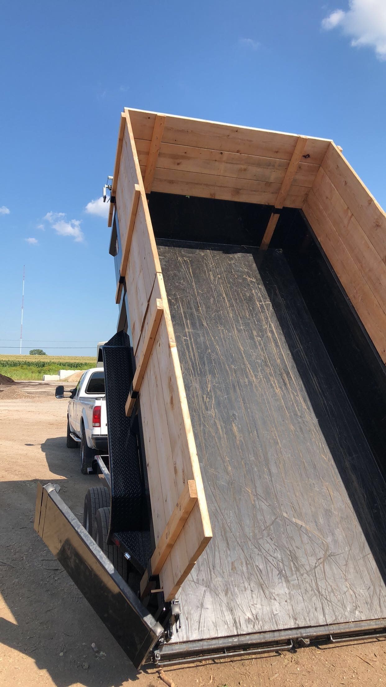 A dump truck is sitting on top of a dirt field.