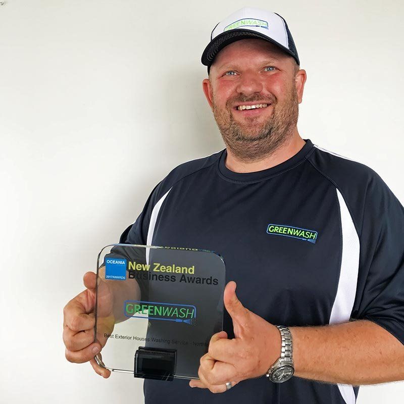 A man is holding a trophy that says new zealand technical awards