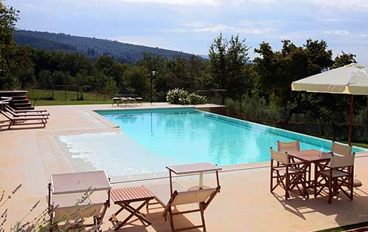 A large swimming pool with chairs and tables around it