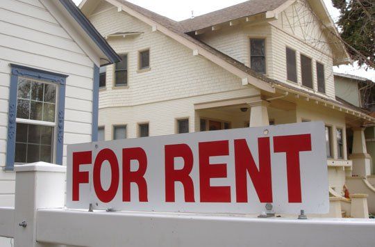 A house with a for rent sign in front of it