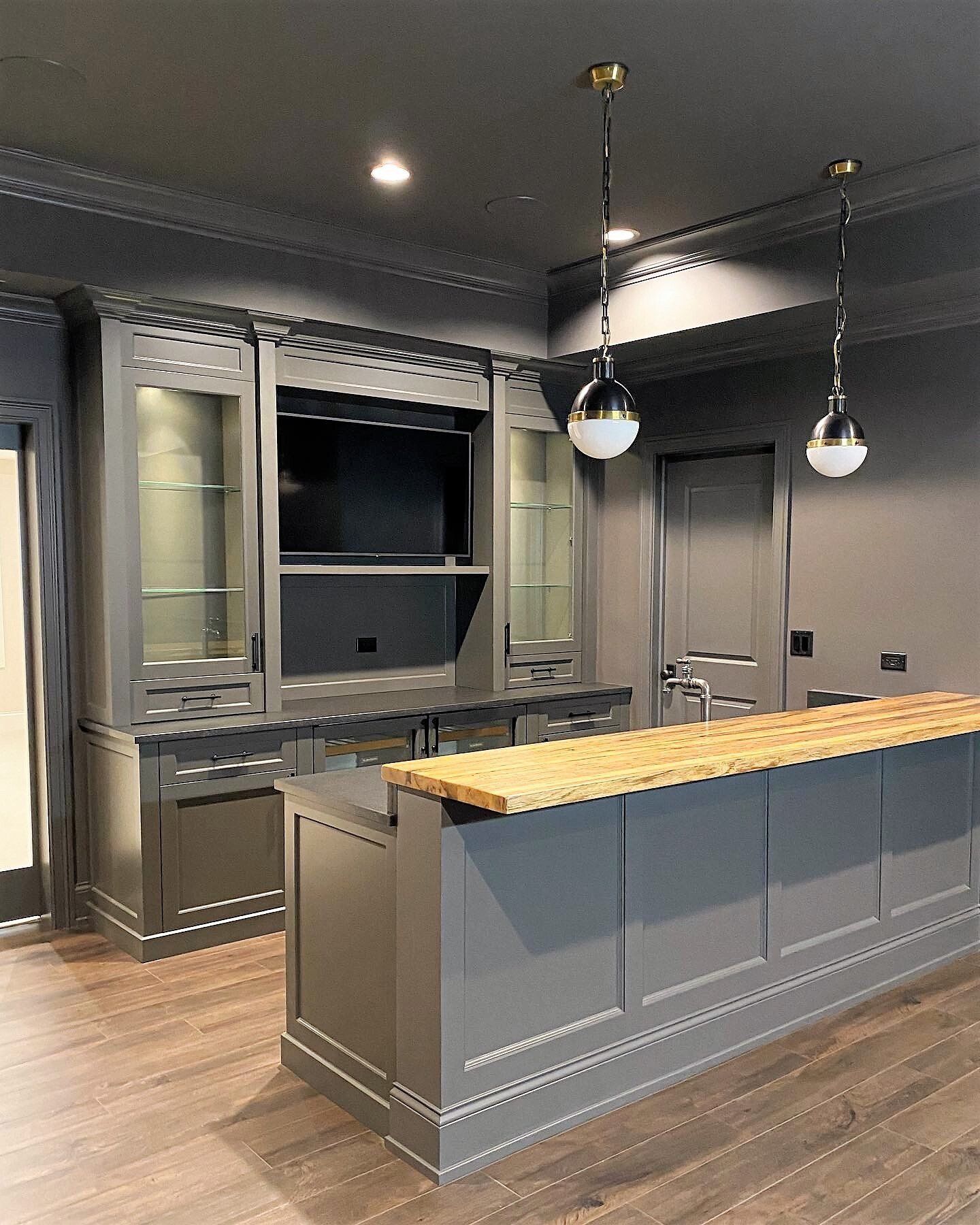 A kitchen with a large island and a television on the wall.