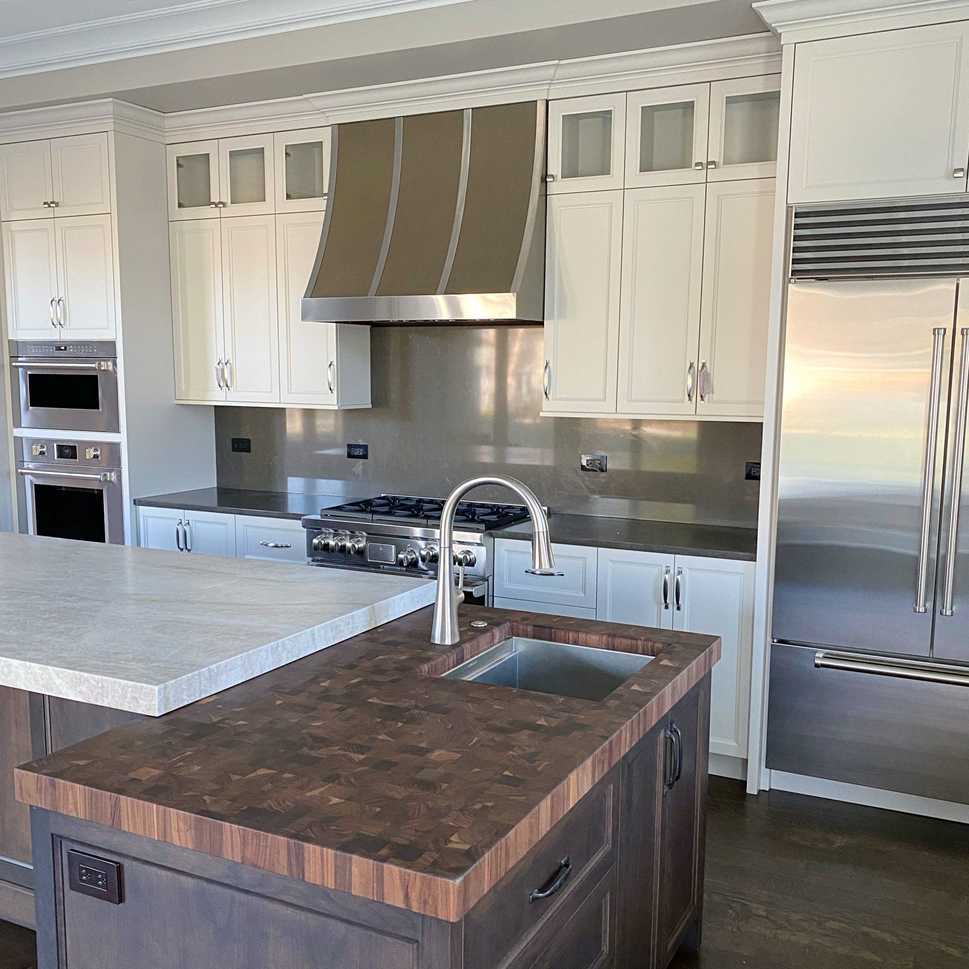 A kitchen with white cabinets and stainless steel appliances