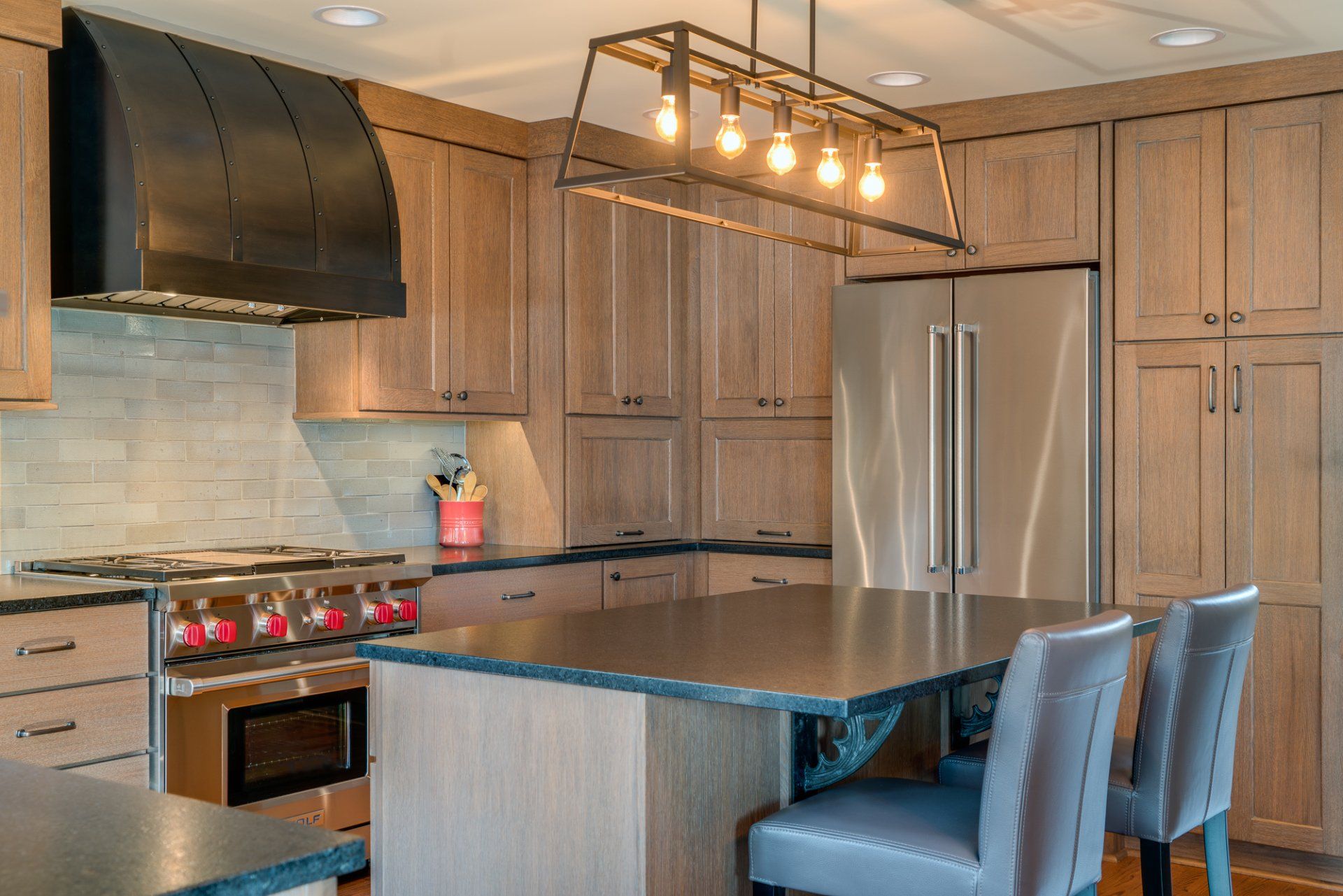 A kitchen with stainless steel appliances , wooden cabinets and a large island.