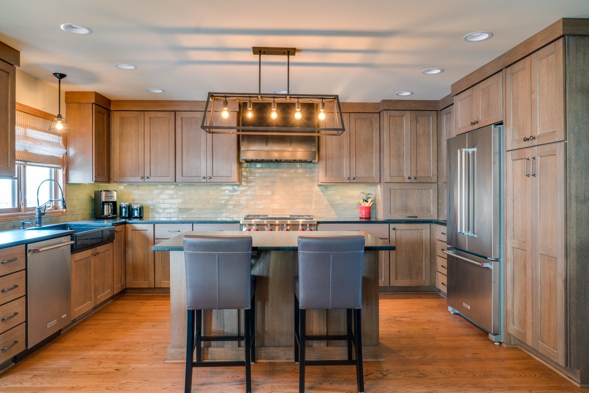 A kitchen with wooden cabinets , stainless steel appliances , and a large island.