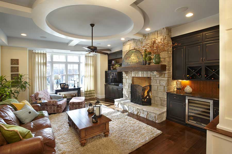 A living room with a fireplace and a ceiling fan