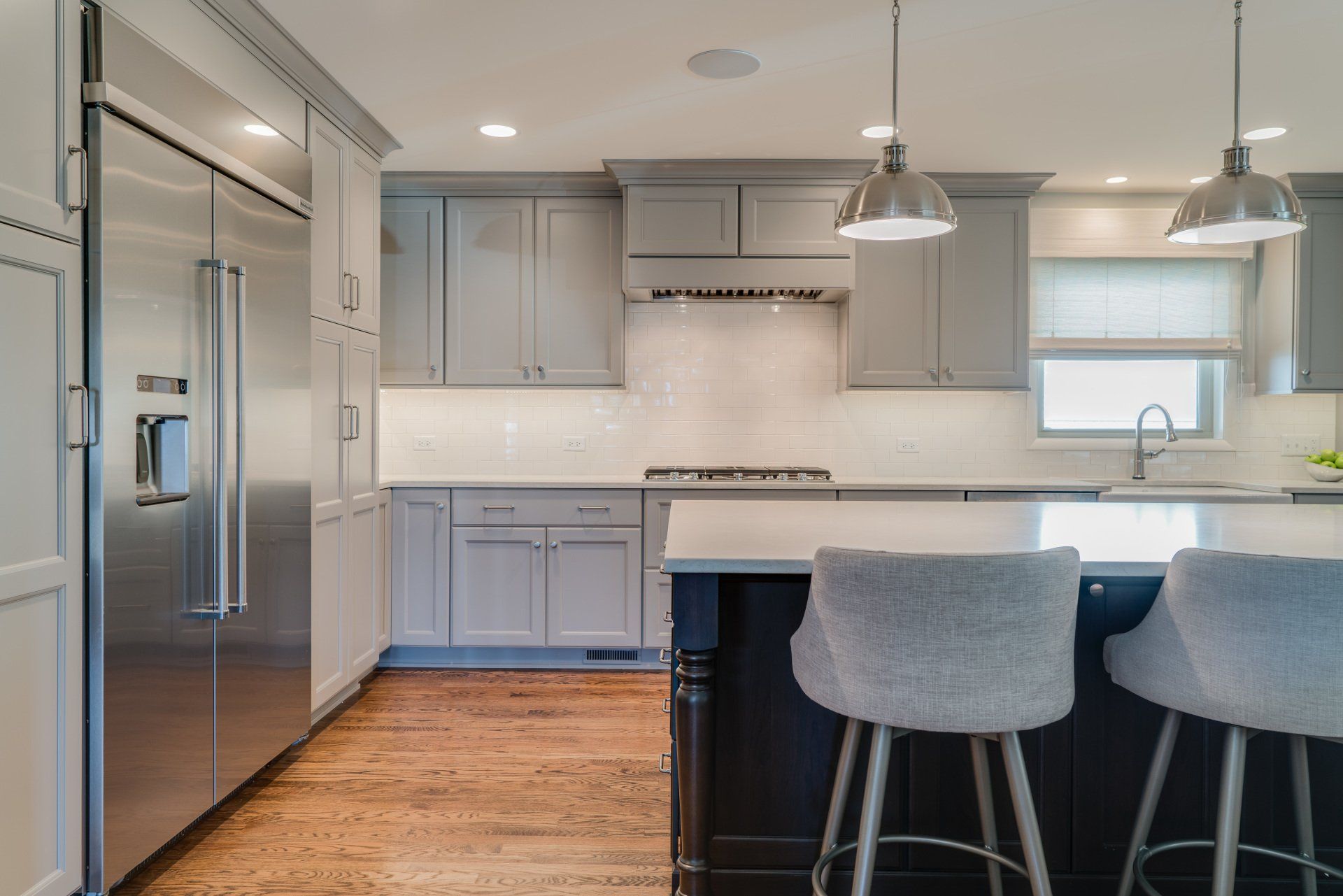 A kitchen with stainless steel appliances and gray cabinets