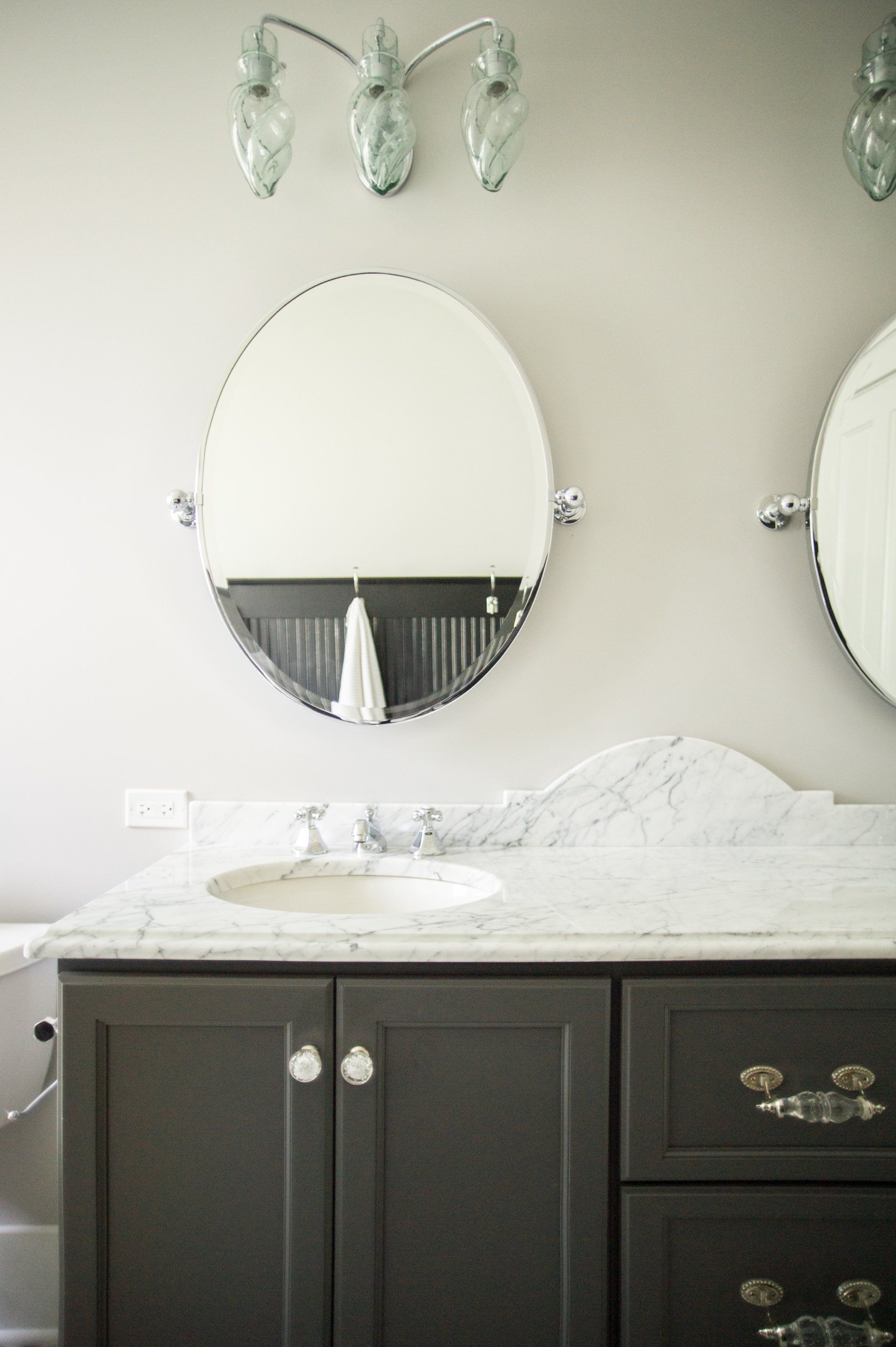 A bathroom with two mirrors and a sink.