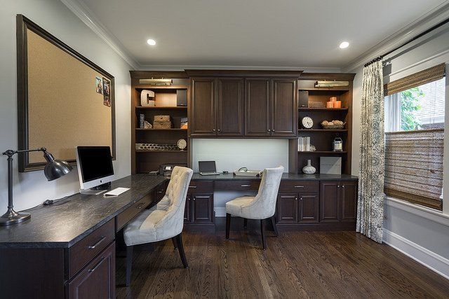 A home office with a desk , chairs and a computer.