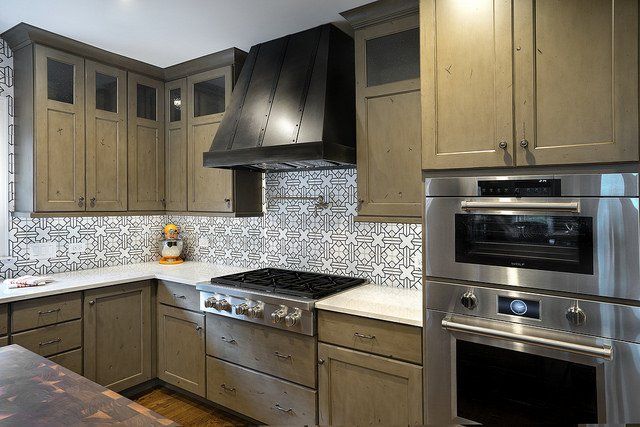 A kitchen with stainless steel appliances and wooden cabinets.