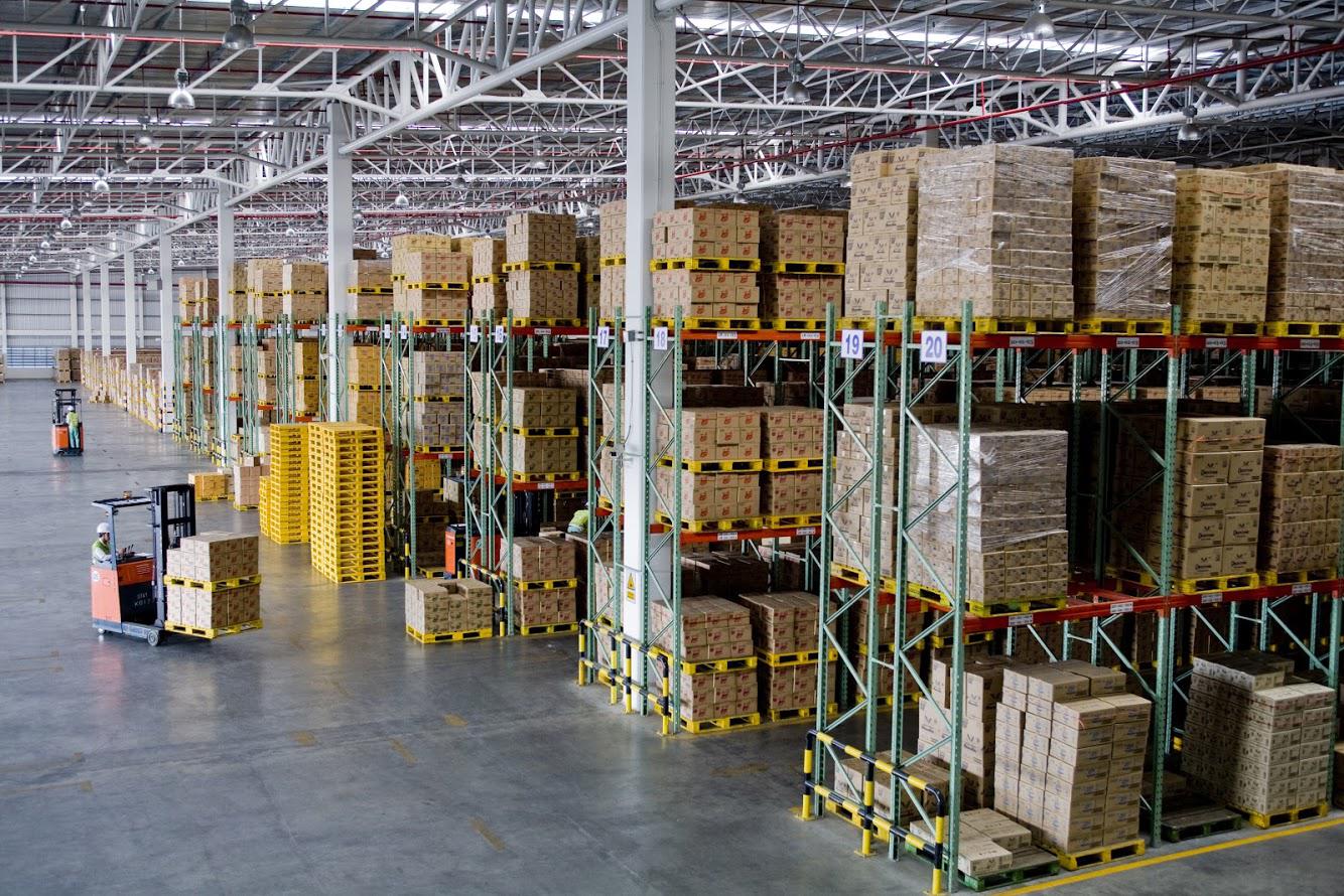 A large warehouse filled with lots of boxes on shelves.