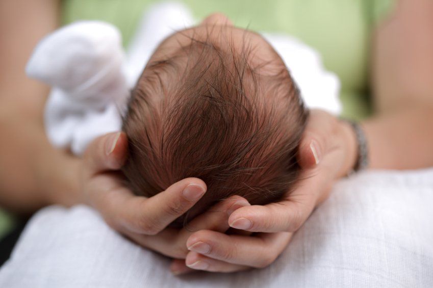 mother cradling baby's head