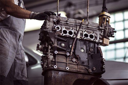 Technician Handling Used Auto Part in Greenville, NC
