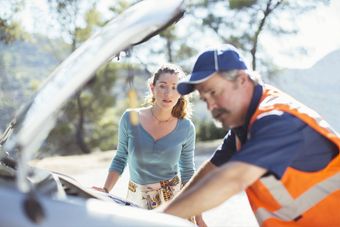 man helping a woman fix her car