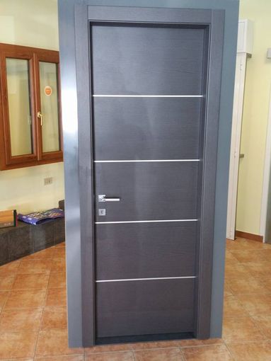 una porta in legno con una maniglia in acciaio