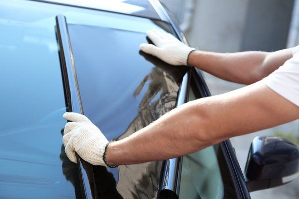 Professional worker installing a tint on a car window — Bay City, TX — CM Auto Glass Inc. & Sign Works
