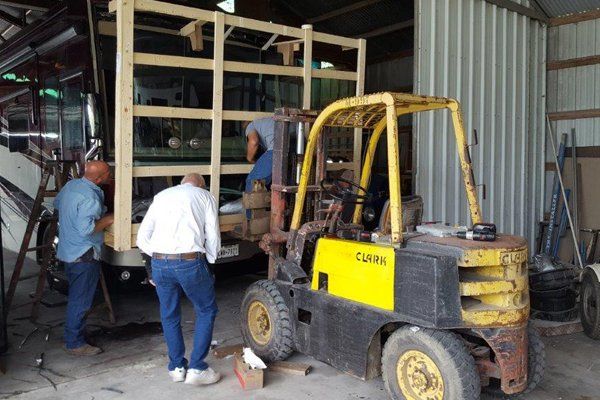 Three professional workers installing a window tint on a bus — Bay City, TX — CM Auto Glass Inc. & Sign Works Three professional workers installing a window tint on a bus — Bay City, TX — CM Auto Glass Inc. & Sign Works