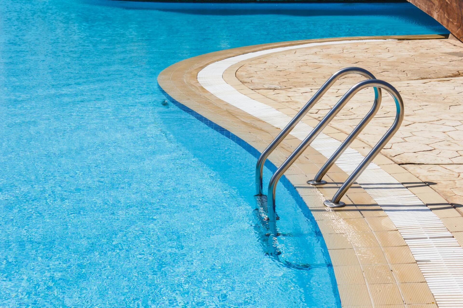clean swimming pool with stamped concrete pool deck