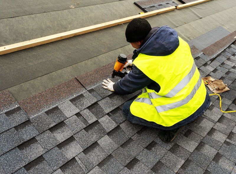 A worker providing a roofing installation solutions in Lenexa, KS A worker providing a roof installation service in Leawood, KS