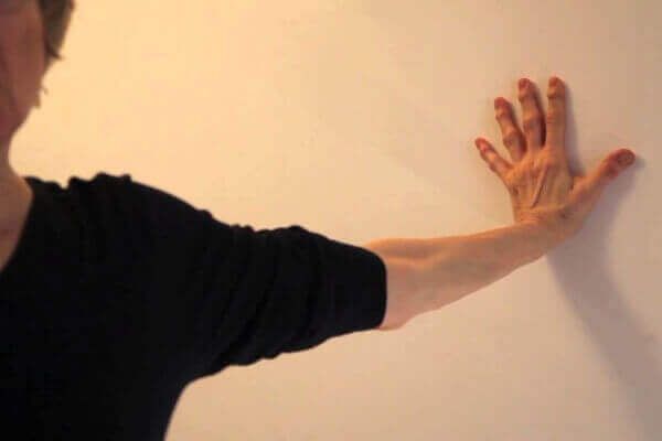 person with their palm against a wall