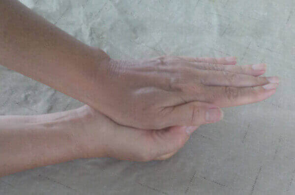 hand pushing down on other hand