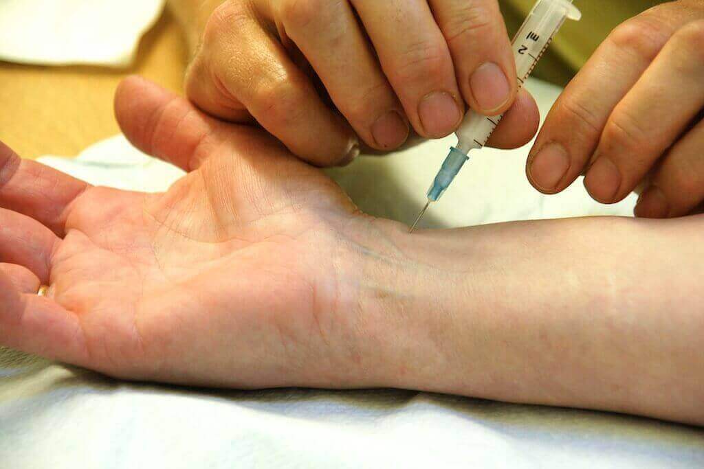 doctor gives a patient a steroid shot in the wrist