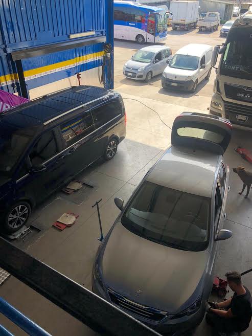 auto ferme in officina durante una riparazione meccanica