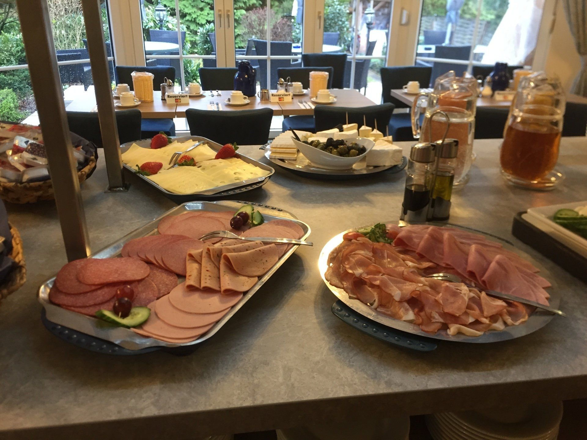 Ein Tisch mit Tellern voller Essen, darunter Schinken und Käse
