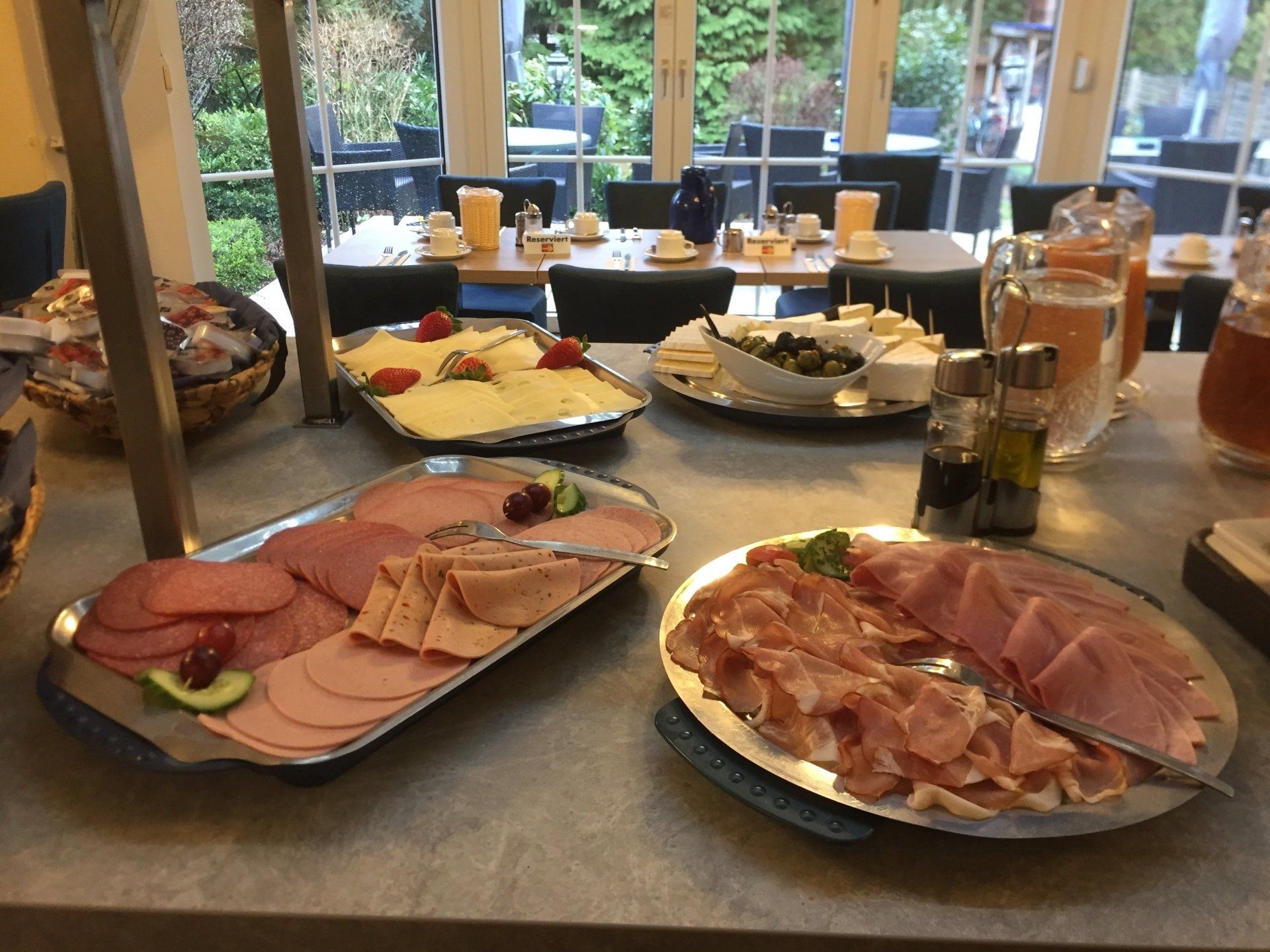 Ein Tisch mit Tellern voller Essen, darunter Schinken und Käse