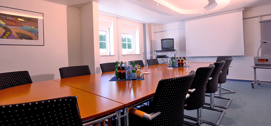 Ein Konferenzraum mit einem langen Tisch und Stühlen