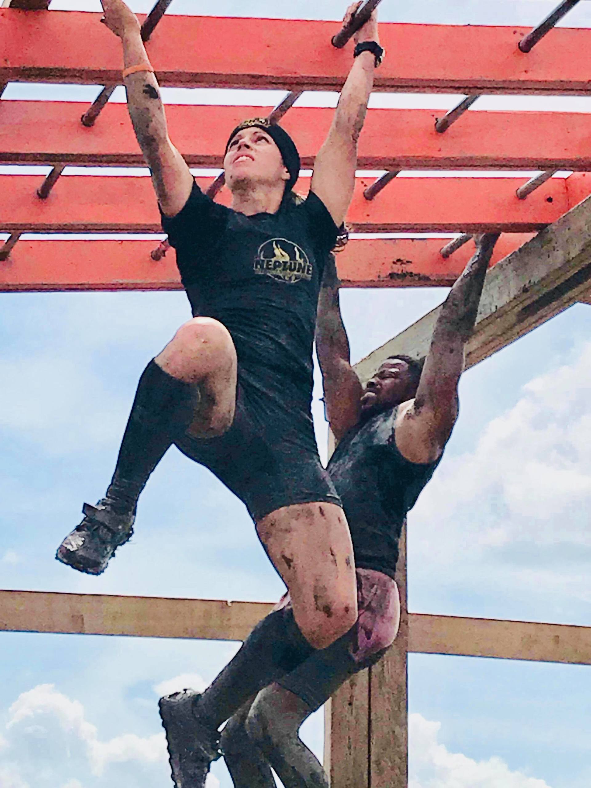 A man and a woman are hanging from a wooden structure.