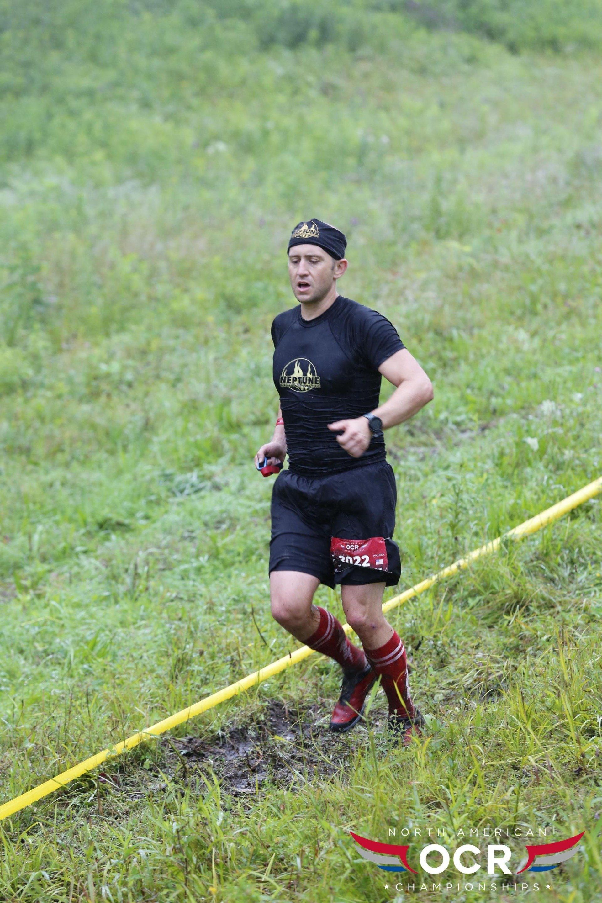 A man is running through a muddy field.