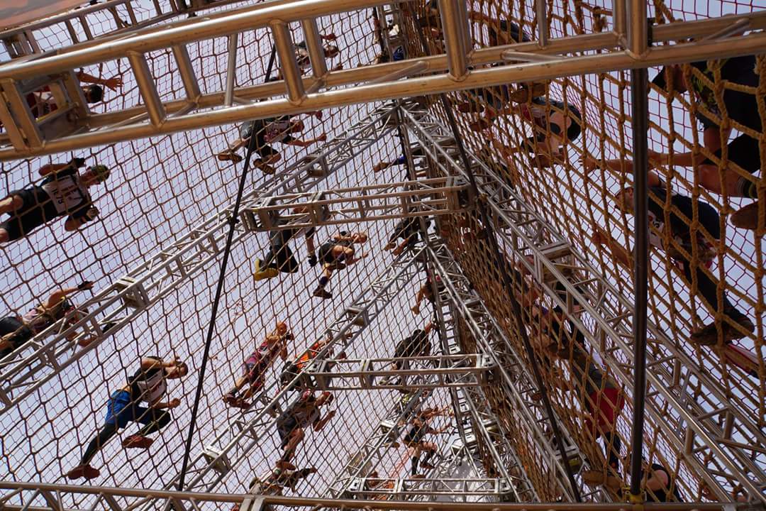 A group of people are sitting on top of a ropes course.