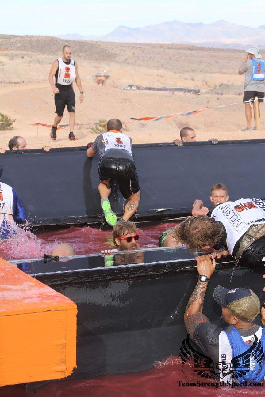 A group of people are playing a game in the mud.