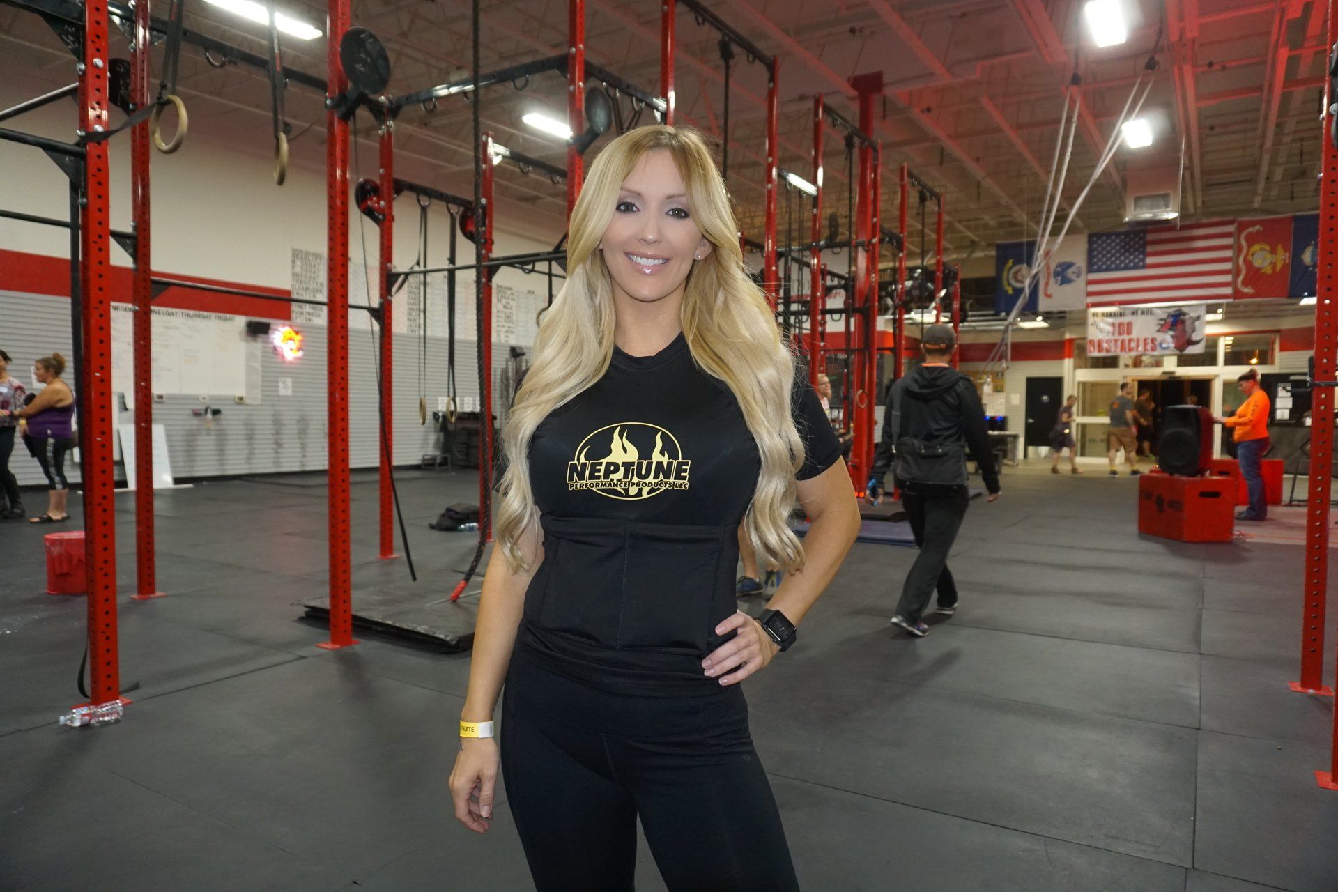 A woman is standing in a gym with her hands on her hips.
