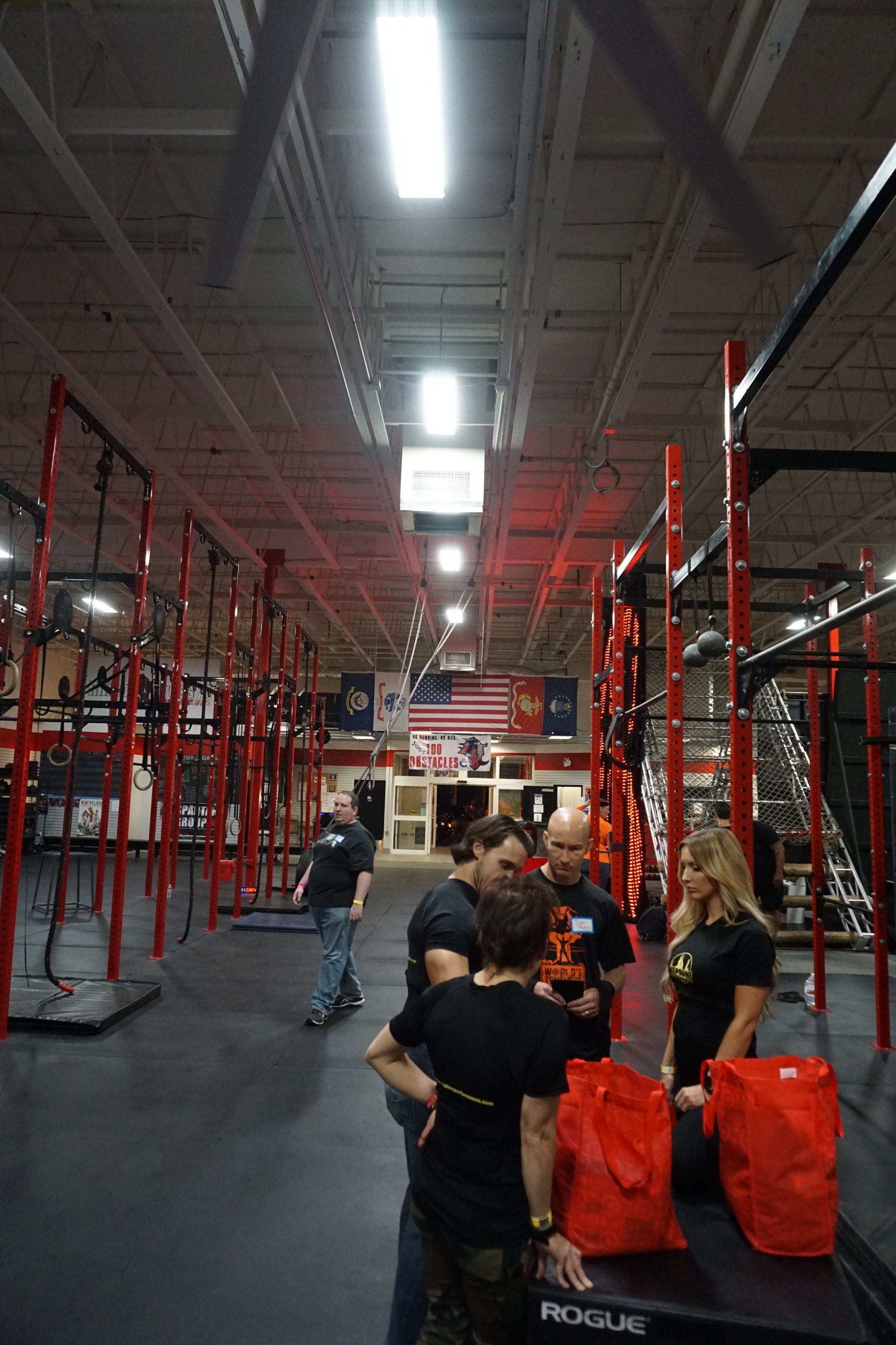 A group of people are standing in a gym talking to each other