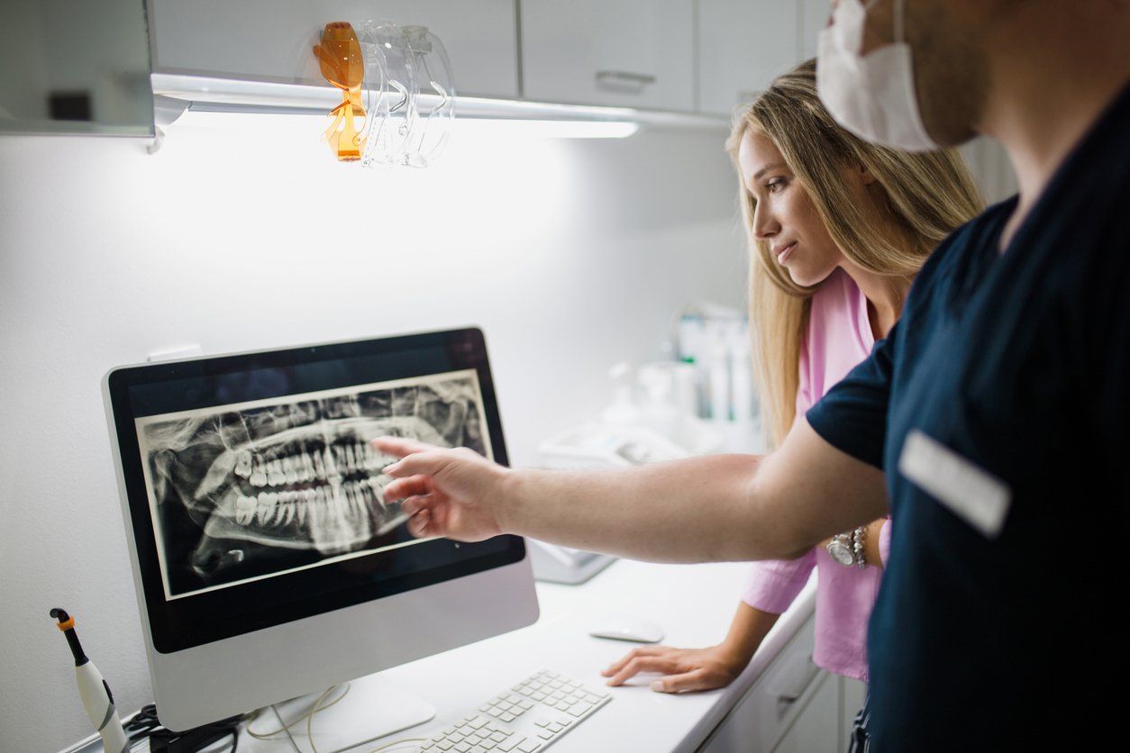 dentist and patient looking at dental xrays