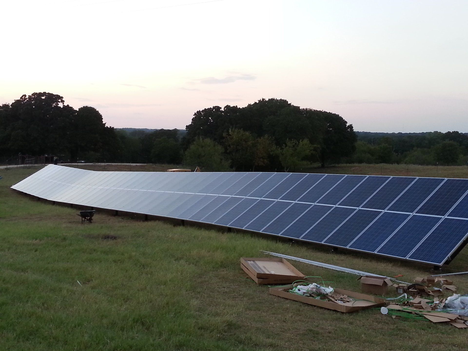 A row of solar panels in a grassy field