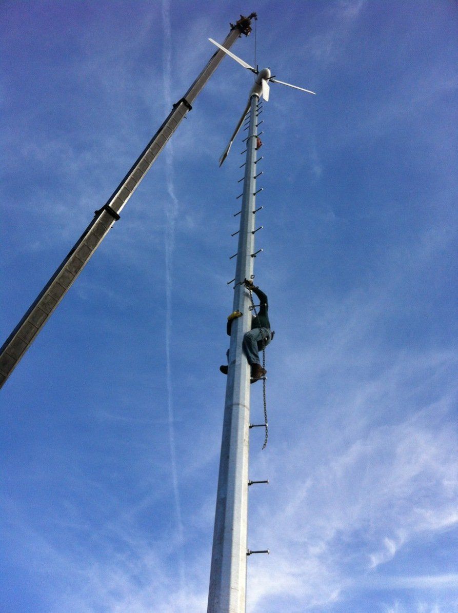 A man is climbing up a very tall pole