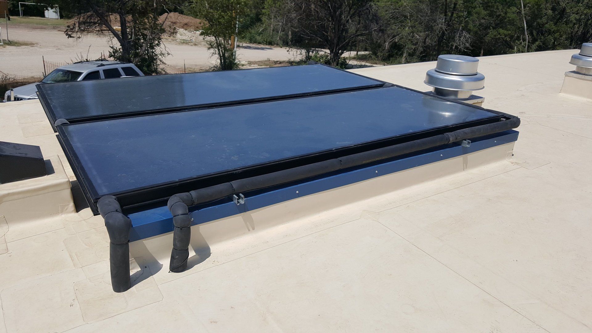 A solar panel is sitting on top of a white roof.