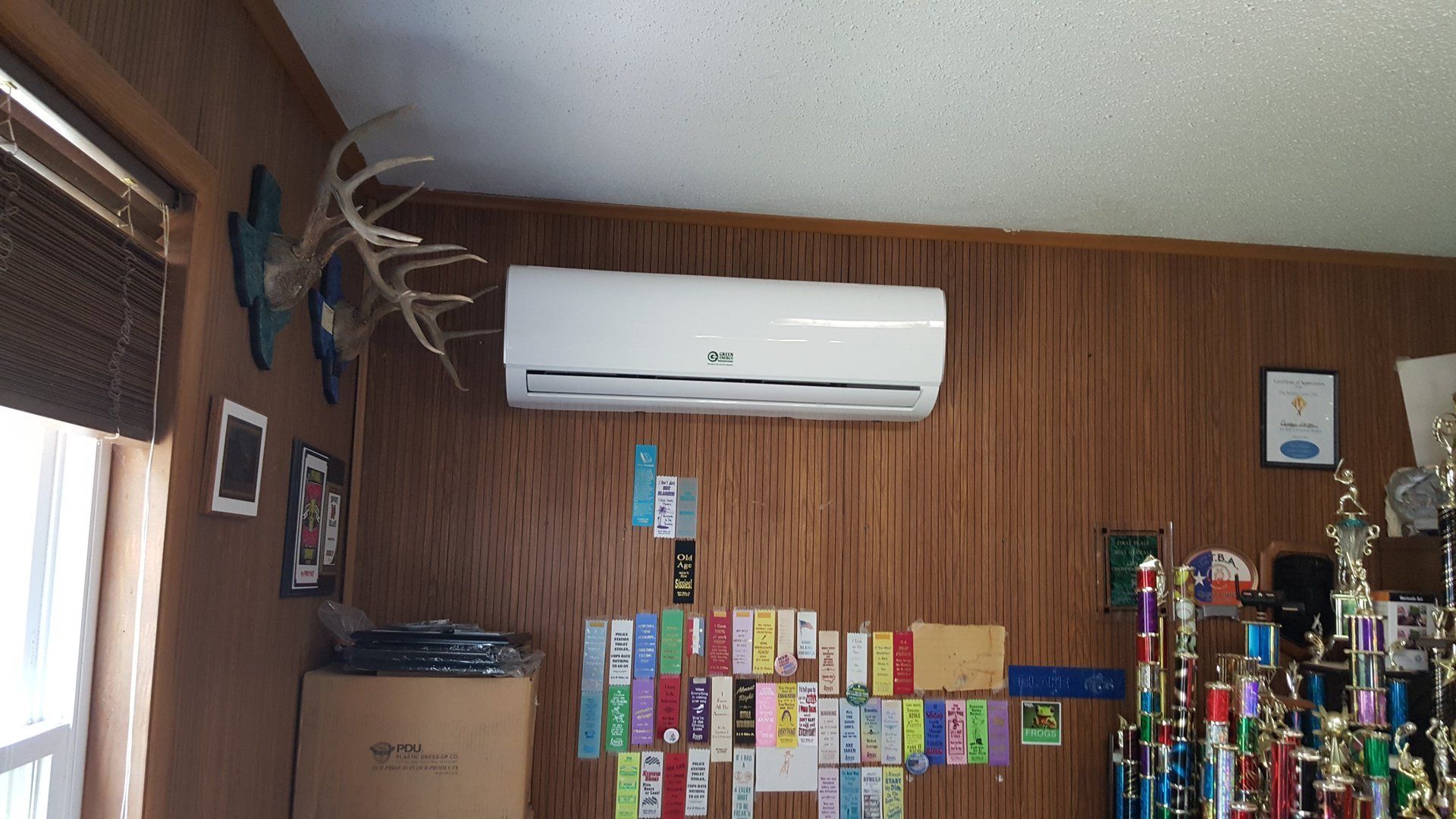 A room with trophies and an air conditioner on the wall