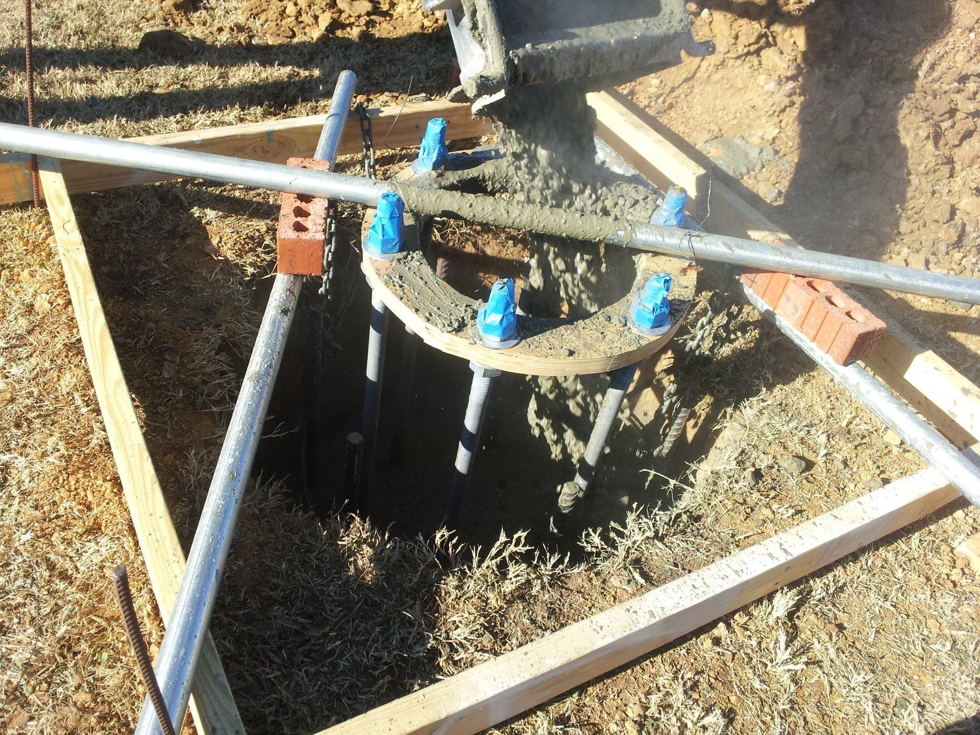 Concrete is being poured into a hole in the ground