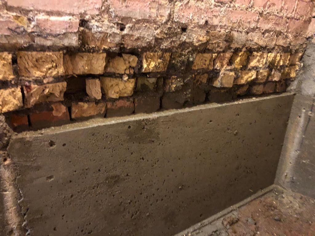 A brick wall with a concrete slab in the middle of it.