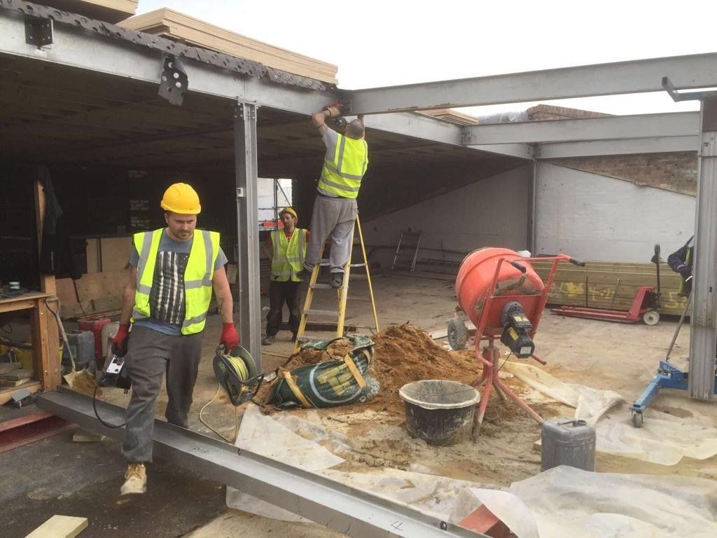 A group of construction workers are working on a building.